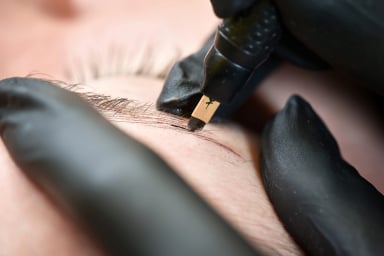 Close-up of eyebrow microblading procedure.